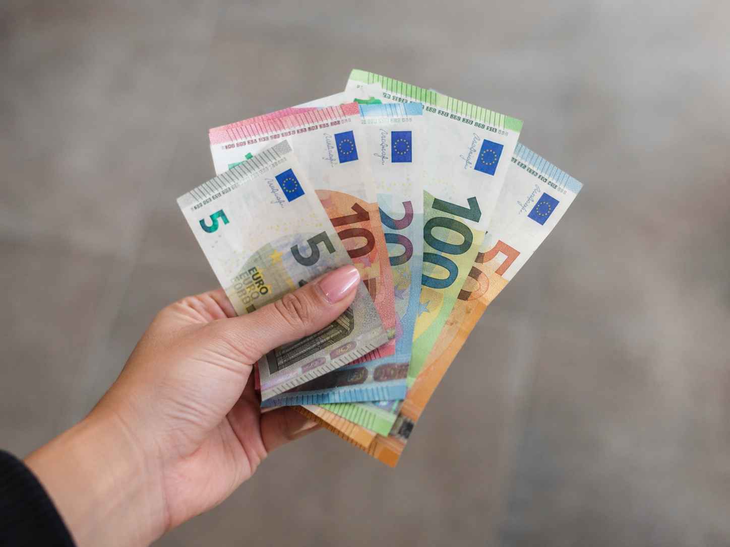 Hand holding euro banknotes representing student expenses and living costs in Frankfurt.